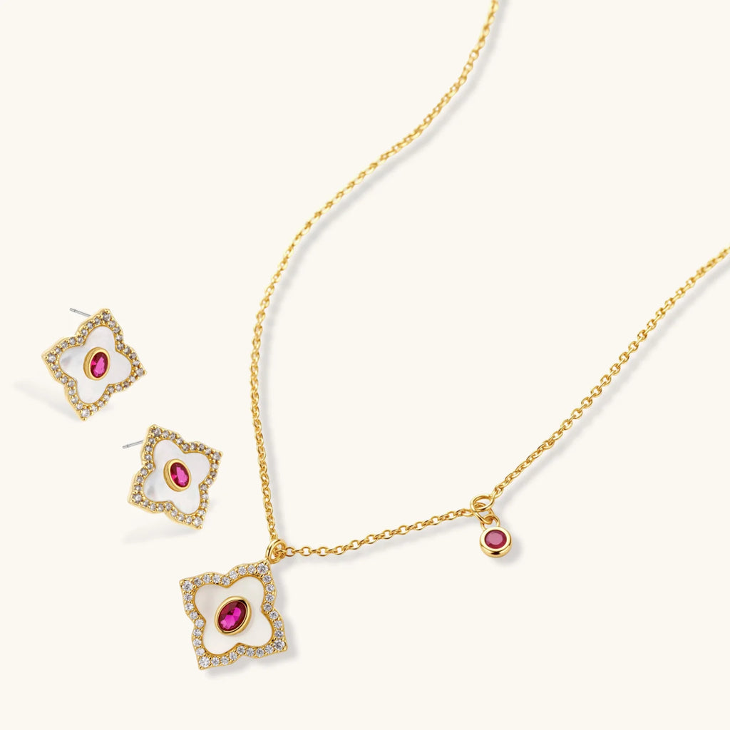 Gold-plated quatrefoil necklace and earring set with white enamel, pink cubic zirconia centers, and crystal borders