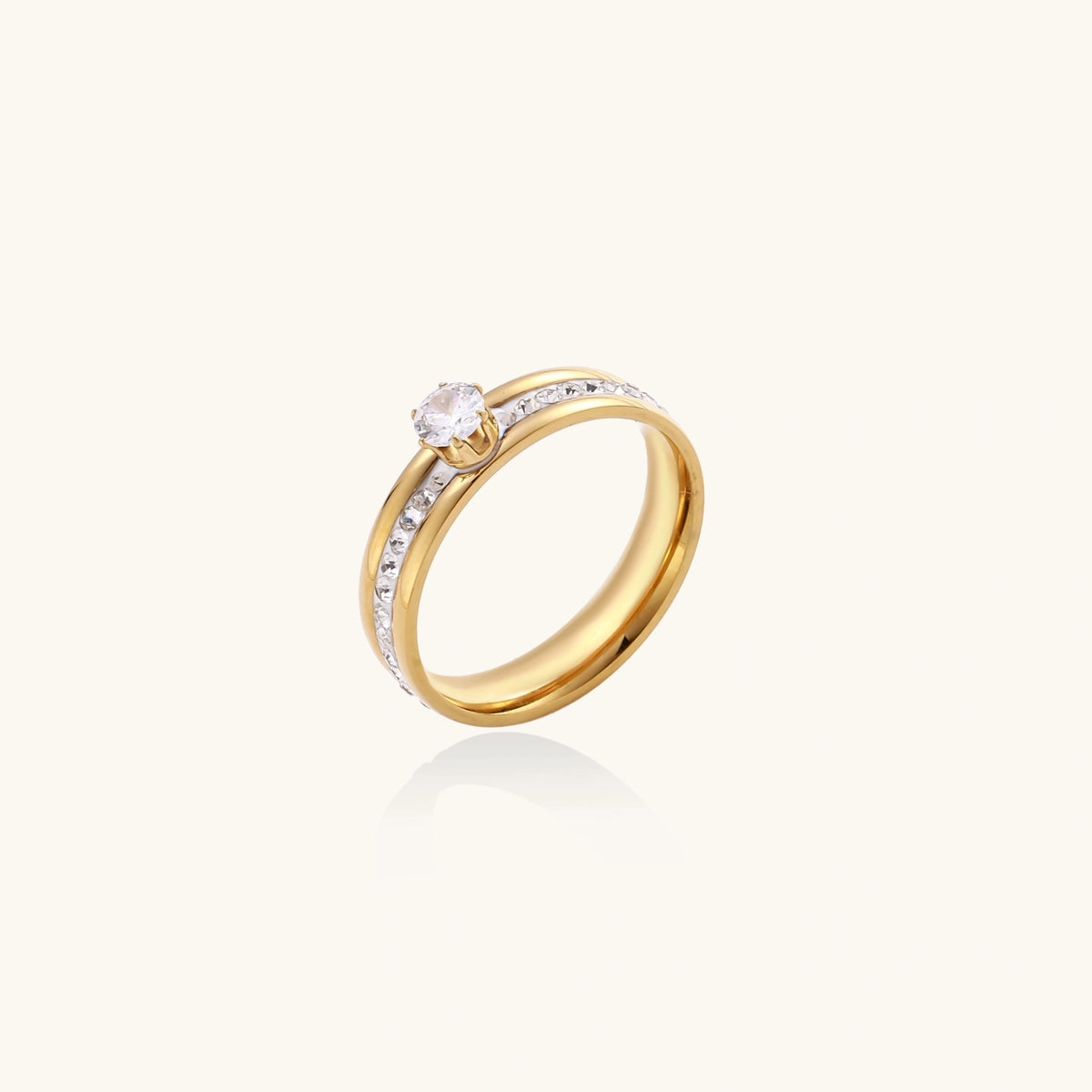 Gold-plated double-band ring with center rhinestone solitaire and channel-set stones on white background
